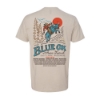 Back of Blue Ox 2025 t-shirt featuring cowboy riding a blue ox with red sun and pine trees. Festival lineup on the bottom