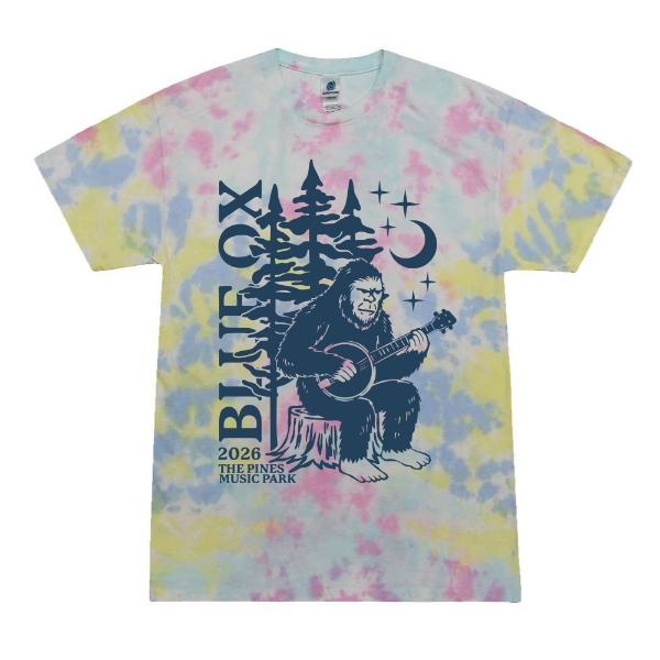 Youth tie dye T-shirt featuring a Sasquatch playing banjo with Blue Ox 2026 text, pine trees, moon, and stars