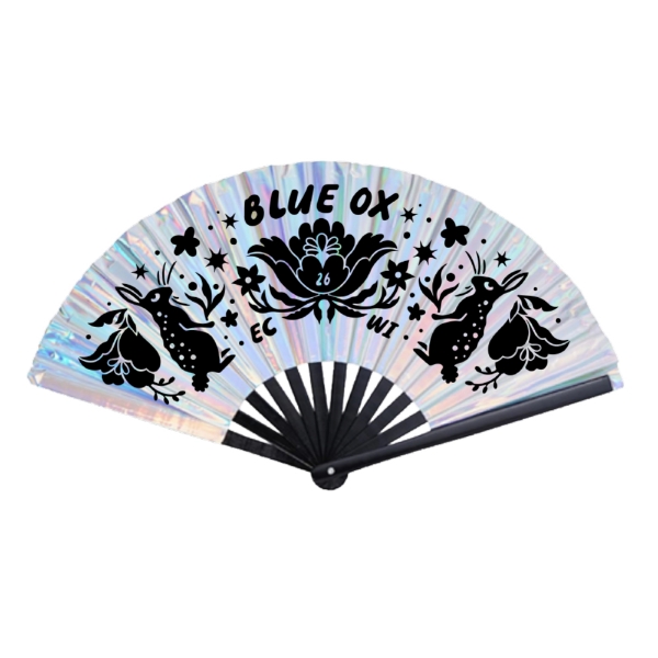 Iridescent Blue Ox Music Festival hand fan with black woodland artwork featuring rabbits, stars, and floral details, measuring 25 by 13 inches